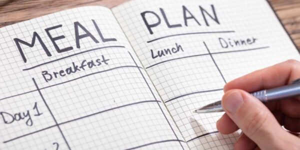 Meal plan_1000x550 Someone writing a meal plan.