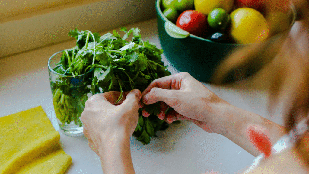 woman picking cilantro leaves from the bunch in their kitchen