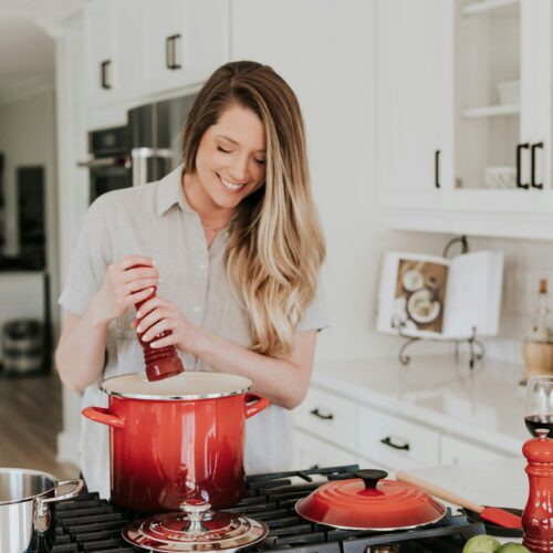 woman seasoning pot in the kitchen
