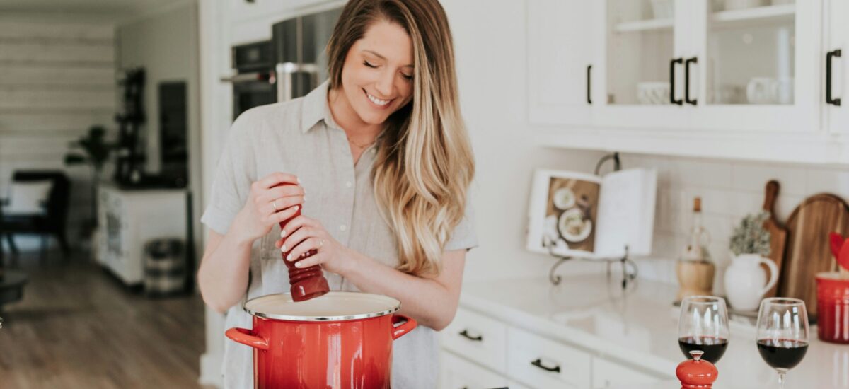 woman seasoning pot in the kitchen